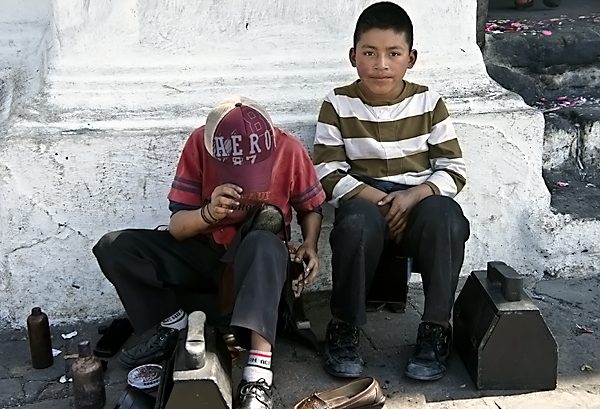 Shoe polish boys working outside the Church of Santo Tomas