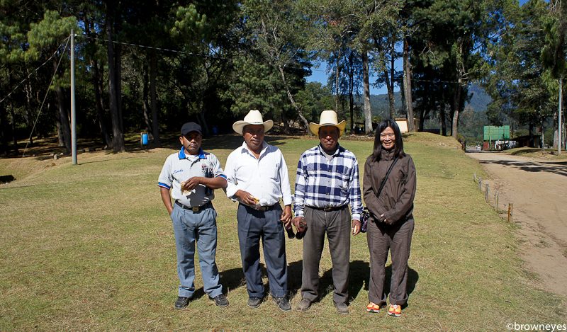 Brown eyes with local men in their straw hat at Iximche