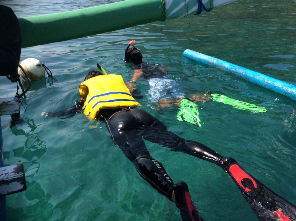 Holding tight to guide in my first snorkeling experience