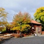 Lady dressed in traditional Swedish costume resting outside a workshop at Skansen