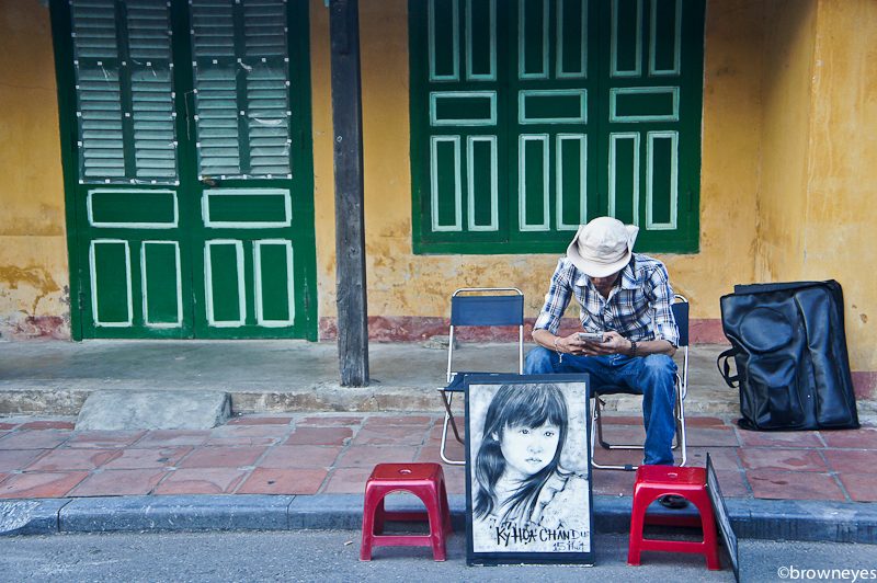 Local artist waiting for tourists to have their portraits drawn in Hoi An.