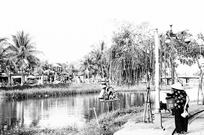 An elderly lady having her morning walk next to the river in Hoi An.